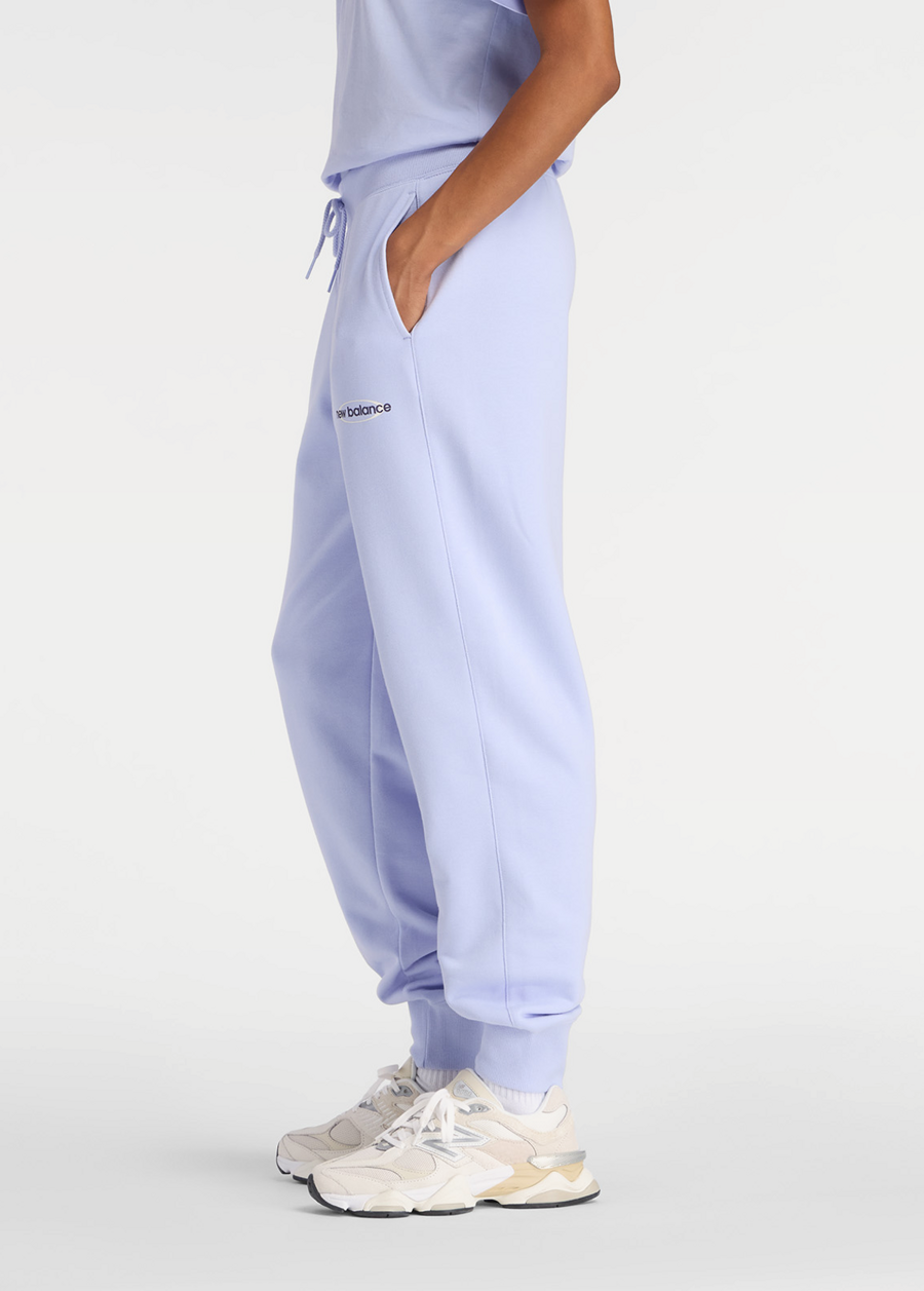 Штаны женские New Balance Sport French Terry Graphic Jogger лилового цвета