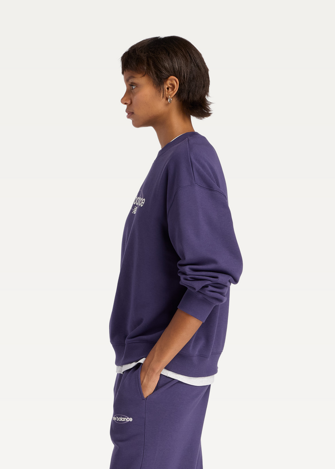 Світшот жіночий New Balance Sport Graphic Oversized Crew фіолетового кольору